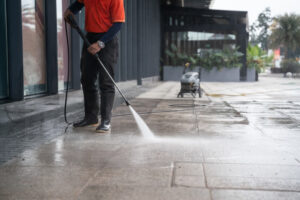 Man cleaning concrete floor for maintenance.