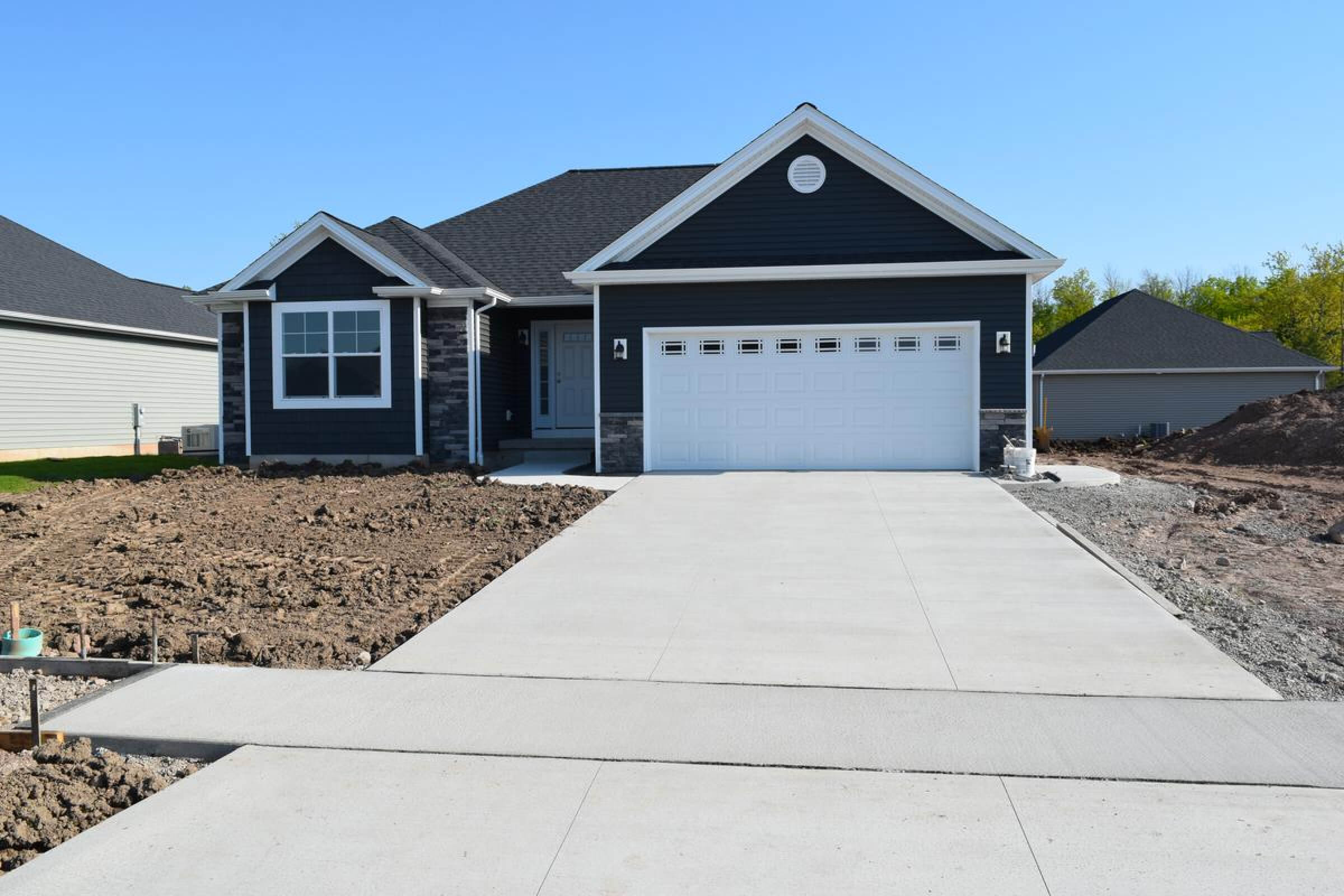 Concrete driveway leading to car garage of a house.