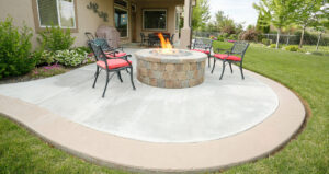 Concrete patio in the backyard, with 2 chars and a fire pit.